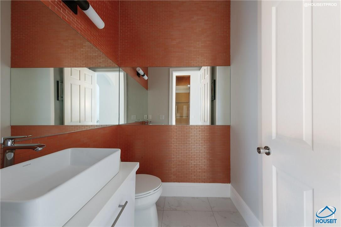 4524 Southwest 195th Way Miramar, FL 33029 - Photo 33 of 36 a blue bathroom with a toilet a sink and a mirror