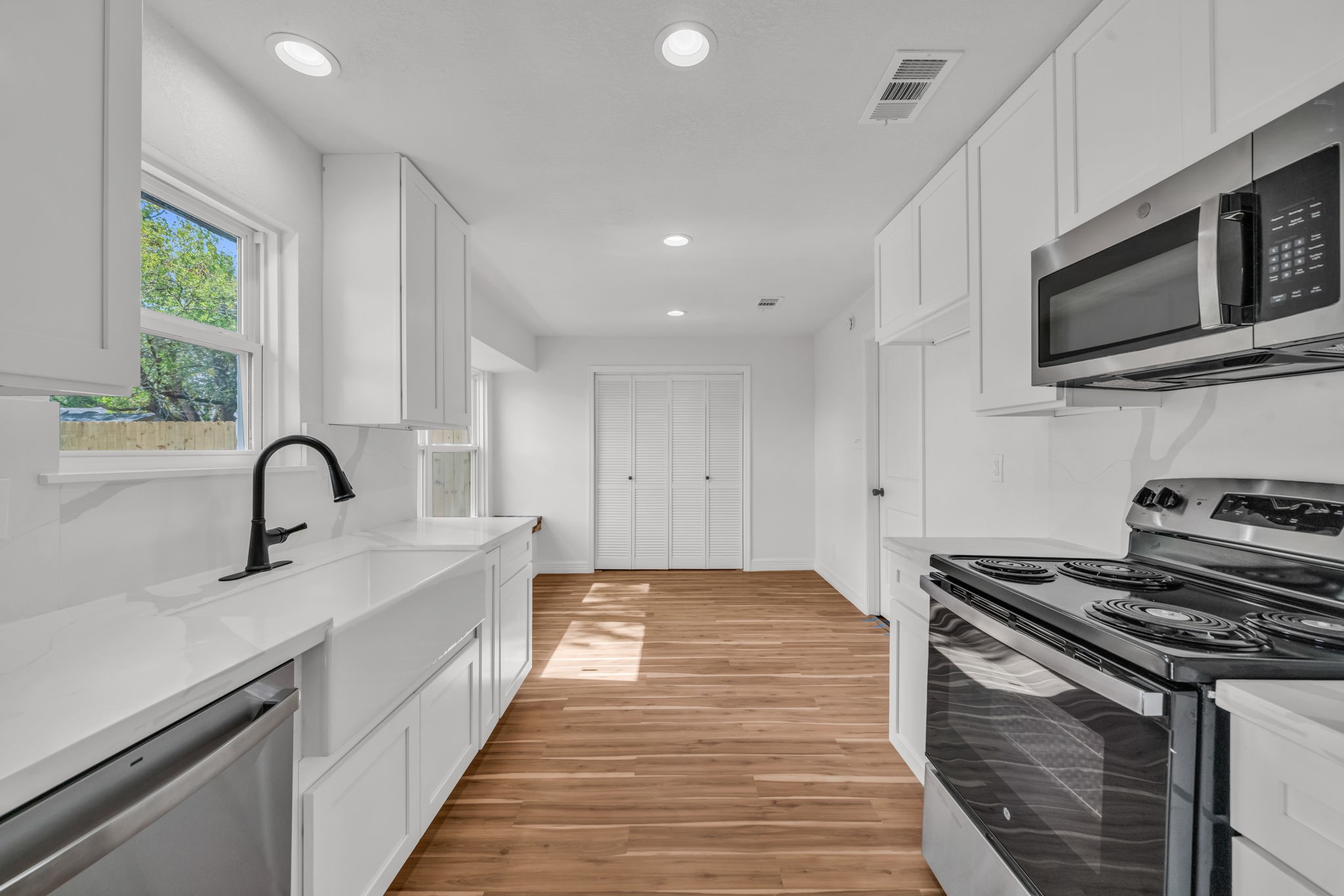 12426 Enchanted Path Drive Houston, TX 77044 - Photo 11 of 28 a kitchen with stainless steel appliances granite countertop a sink a stove and microwave