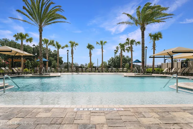 a view of a swimming pool with a patio and a yard