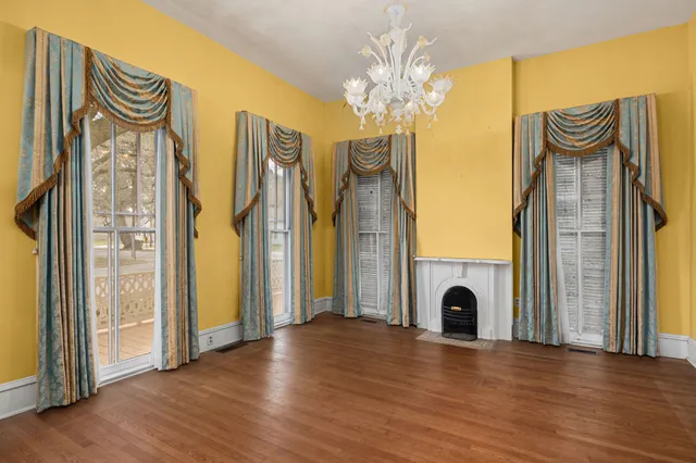a view of a chandelier with wooden floor and a fireplace