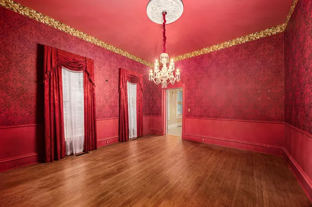 a view of a room with wooden floor and a chandelier