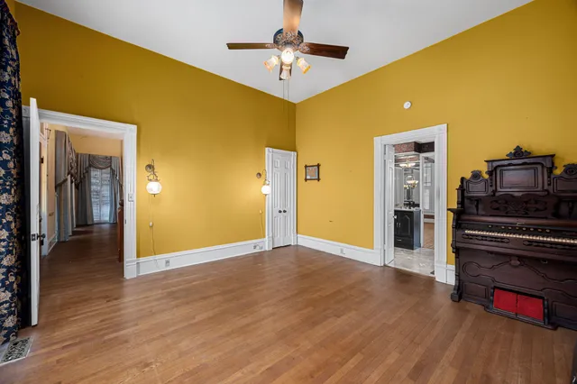 a view of a livingroom with wooden floor and a kitchen space