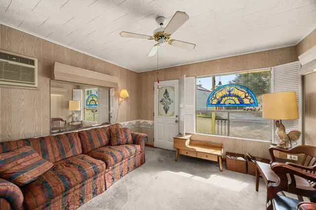 a living room with furniture a rug and a ceiling fan
