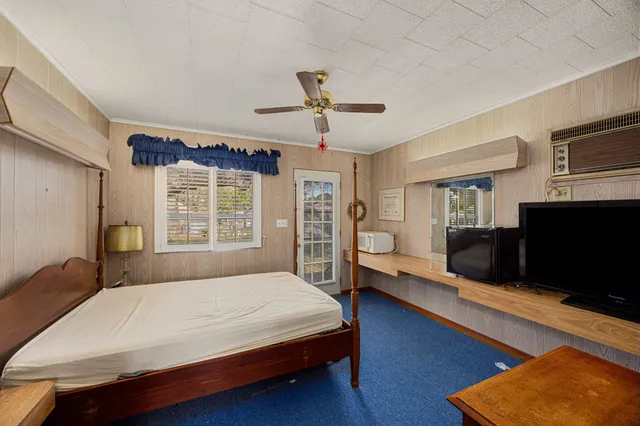 a spacious bedroom with a bed and wooden floor