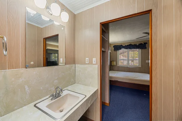 a en suite bathroom with a sink a light fixture and a mirror