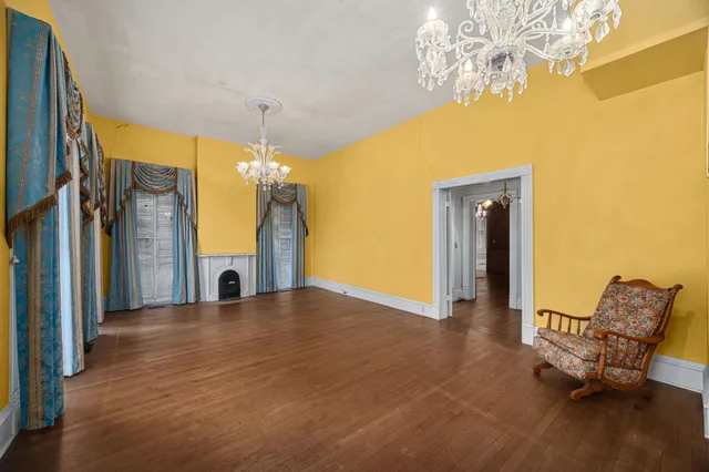 a view of a livingroom with furniture a chandelier and wooden floor