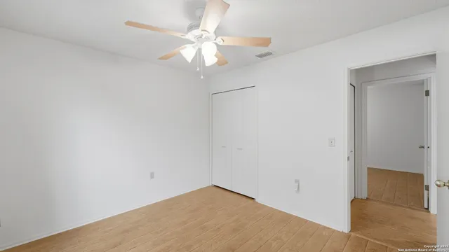 an empty room with a chandelier fan