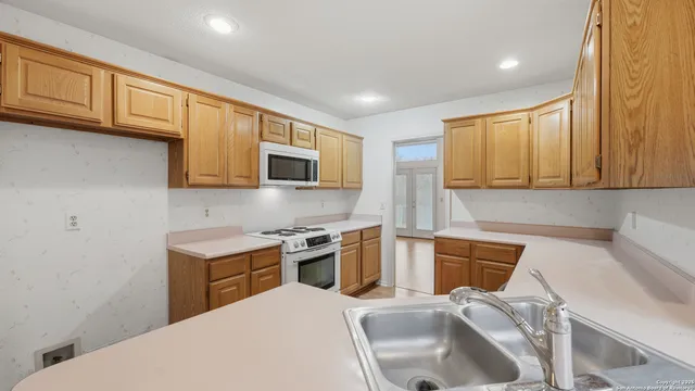 a kitchen with stainless steel appliances granite countertop a sink stove and microwave