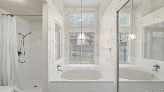 a bathroom with a tub shower and sink