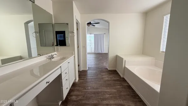 a bathroom with a double vanity sink a mirror and a bathtub