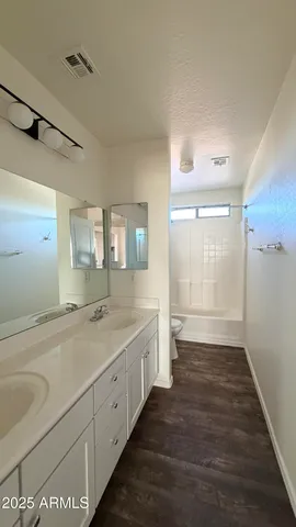 a spacious bathroom with a granite countertop sink and a mirror
