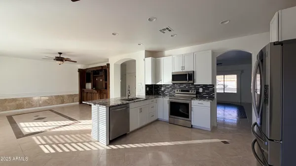 a kitchen with stainless steel appliances granite countertop a stove refrigerator and microwave