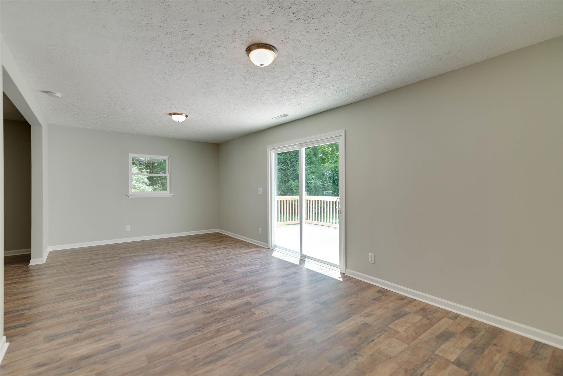 456 Boiling Springs Road Portland, TN 37148 - Photo 12 of 28 an empty room with wooden floor and windows