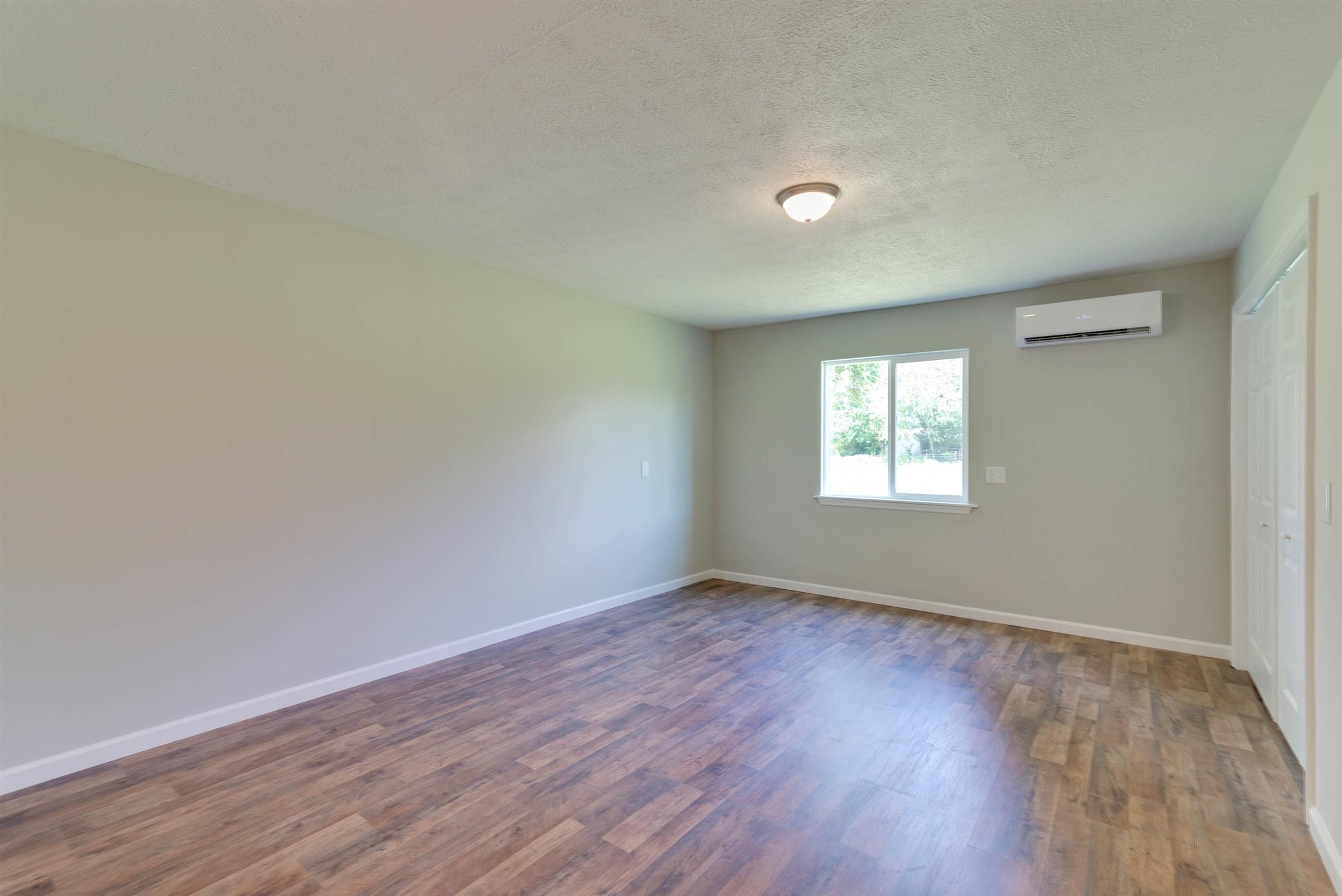 456 Boiling Springs Road Portland, TN 37148 - Photo 14 of 28 an empty room with wooden floor and windows
