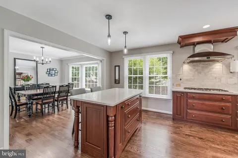a large kitchen with stainless steel appliances granite countertop a lot of counter space and wooden floors