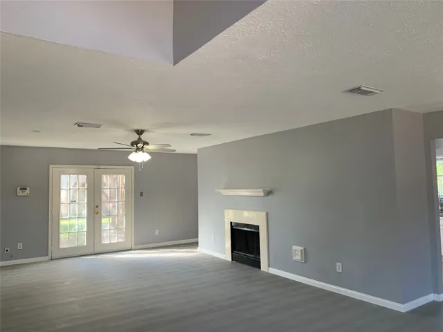 a view of an empty room with a fireplace and a window