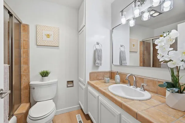 a bathroom with a granite countertop toilet sink and mirror