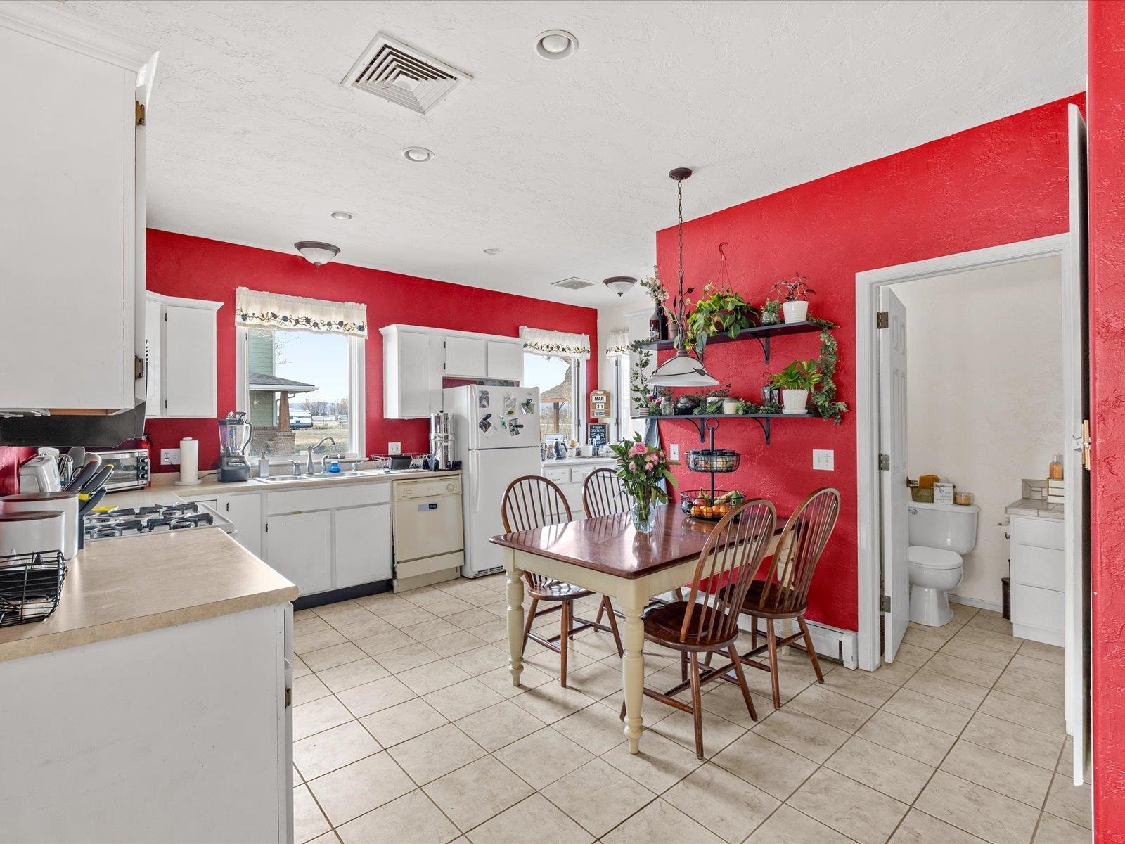 1891 J J 6/10 Road Fruita, CO 81521 - Photo 35 of 41 a kitchen with stainless steel appliances kitchen island granite countertop a dining table chairs and a large window