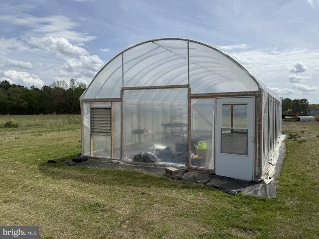 a view of a big house with a big yard and large trees