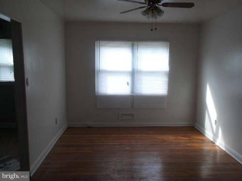945 Southridge Road Baltimore, MD 21228 - Photo 2 of 7 an empty room with wooden floor and windows