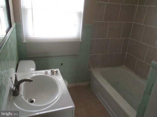 945 Southridge Road Baltimore, MD 21228 - Photo 6 of 7 a bathroom with a sink and bathtub