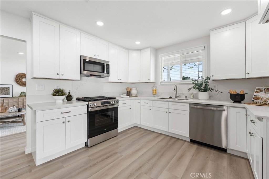 727 North Burney Street Rialto, CA 92376 - Photo 13 of 40 a kitchen with granite countertop white cabinets and white stainless steel appliances