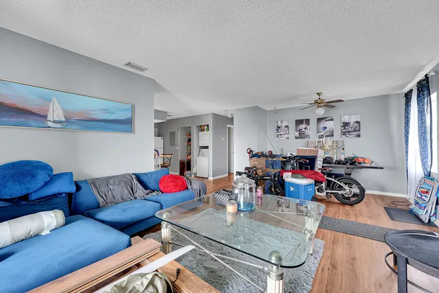 a living room with furniture and a dining table with wooden floor