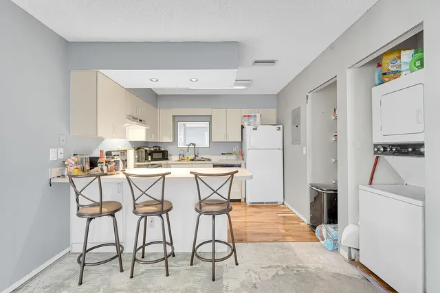 a view of a kitchen with furniture and a refrigerator