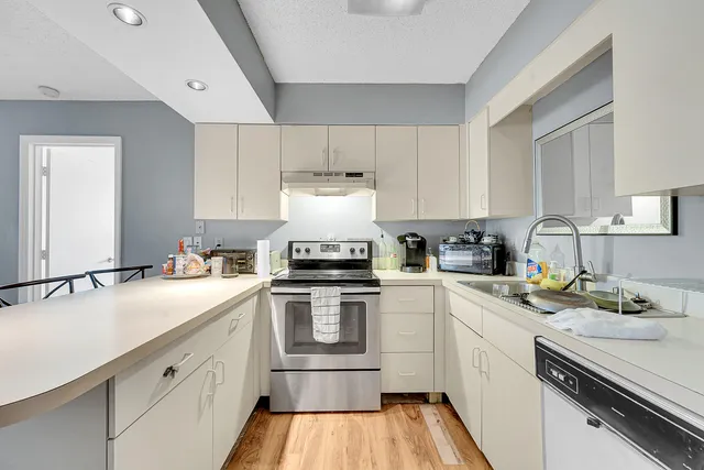 a kitchen with a sink cabinets and white appliances