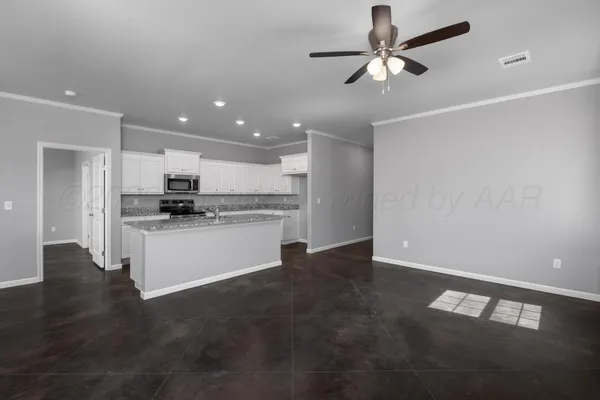 a view of kitchen with refrigerator and white cabinets