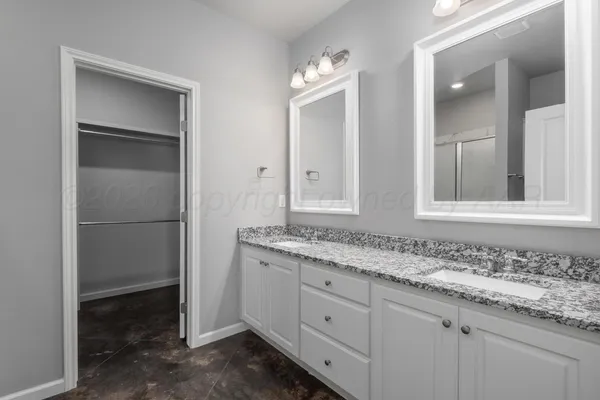 a bathroom with a granite countertop sink a toilet and a mirror