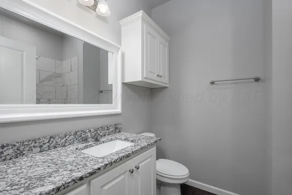 a bathroom with a granite countertop bathtub shower and vanity