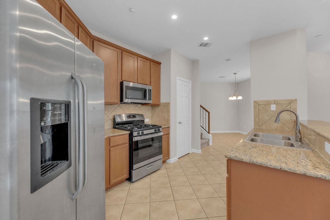 14815 Avery Ranch Boulevard, Unit 403/4B Austin, TX 78717 - Photo 11 of 38 a kitchen with stainless steel appliances granite countertop a refrigerator stove and sink