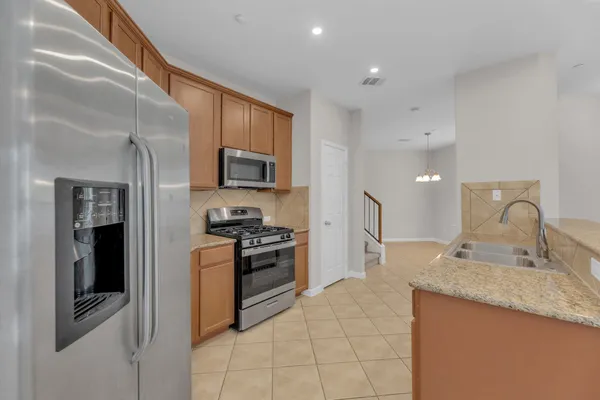a kitchen with stainless steel appliances granite countertop a refrigerator stove and sink