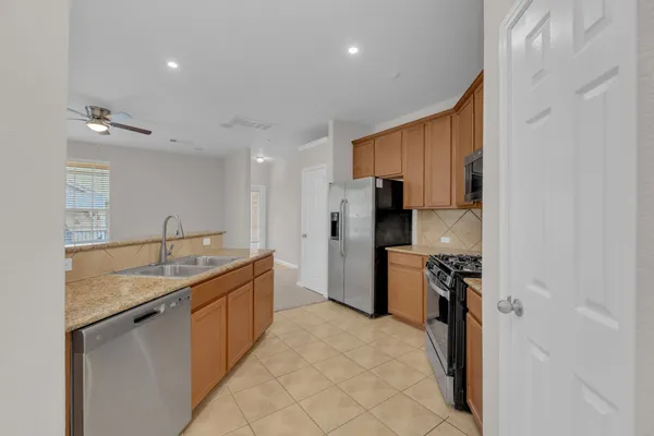a kitchen with stainless steel appliances granite countertop a sink refrigerator and cabinets