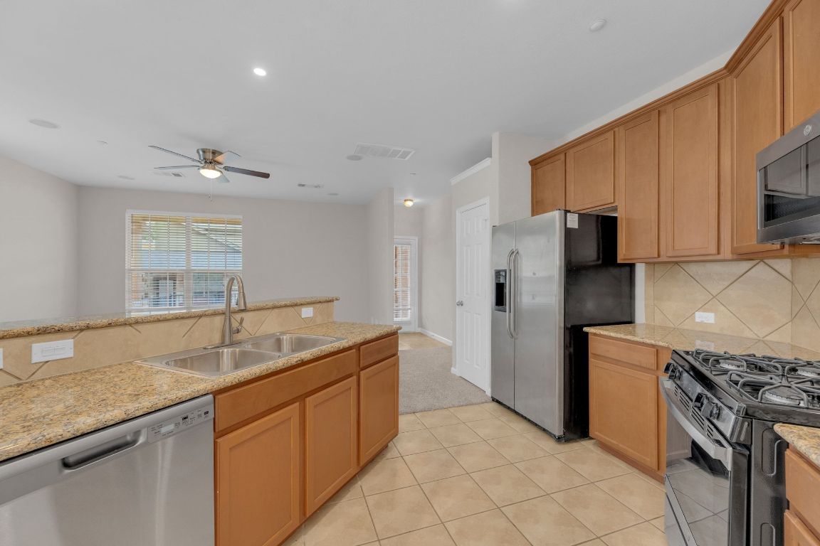 14815 Avery Ranch Boulevard, Unit 403/4B Austin, TX 78717 - Photo 13 of 38 a kitchen with a sink stove and refrigerator