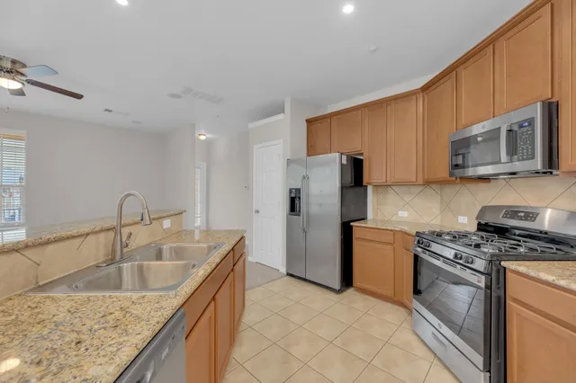 a kitchen with a sink a microwave a refrigerator and cabinets