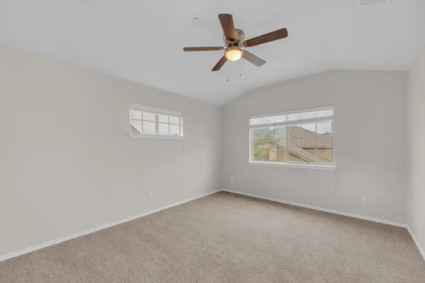 an empty room with a window and a ceiling fan