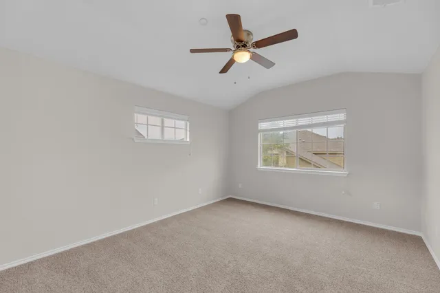 an empty room with a window and a ceiling fan
