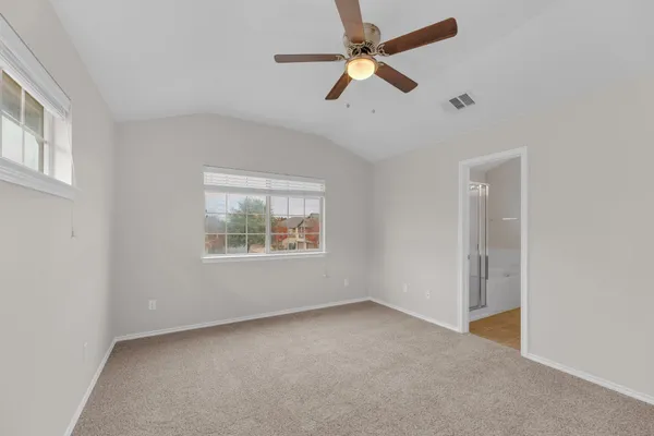 an empty room with a window and a fan