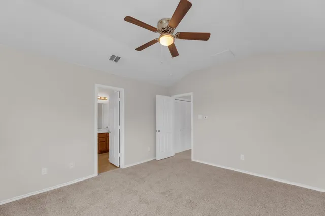an empty room with closet and ceiling fan