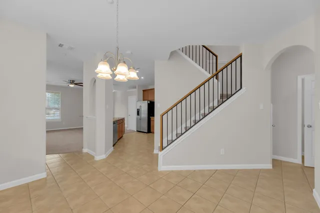 a view of a hallway with entryway and chandelier