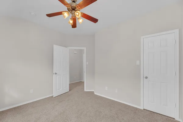 an empty room with chandelier fan