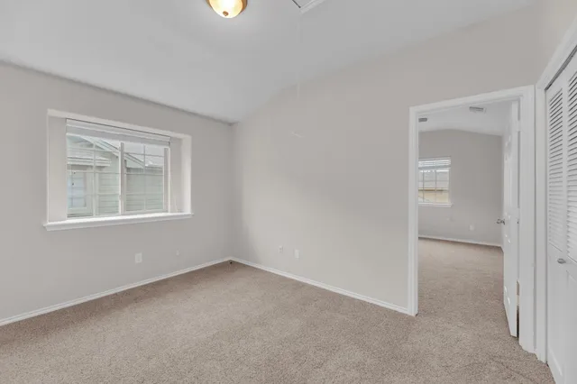 an empty room with windows and closet