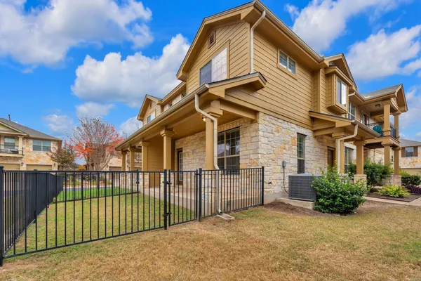 a view of a house with a wooden fence