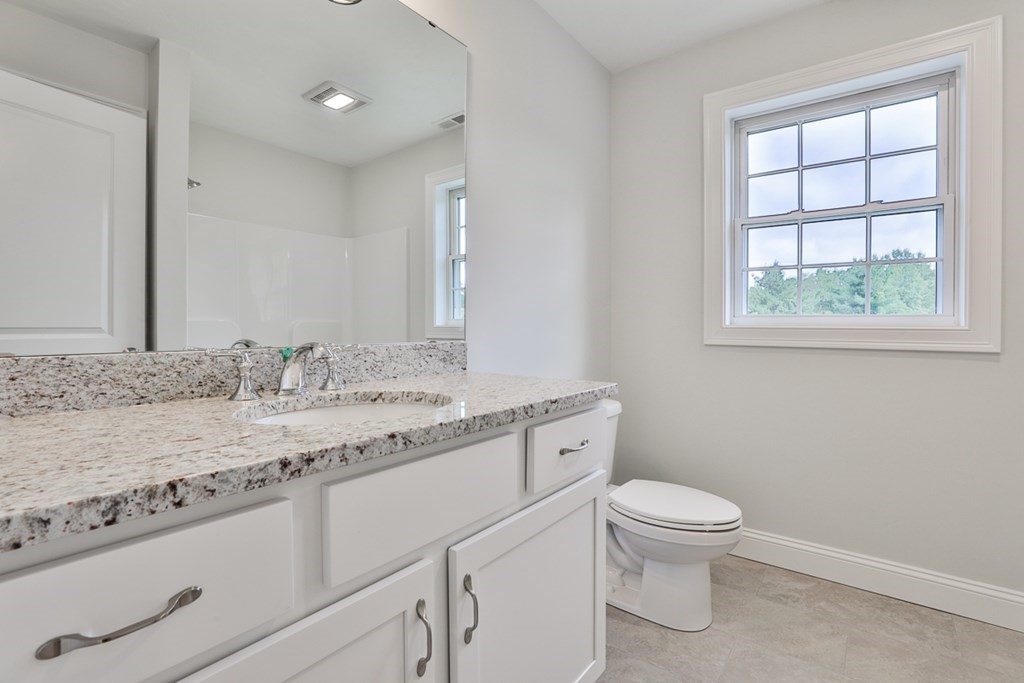 492 Northfield Road Lunenburg, MA 01462 - Photo 14 of 39 a bathroom with a granite countertop sink a toilet and a window