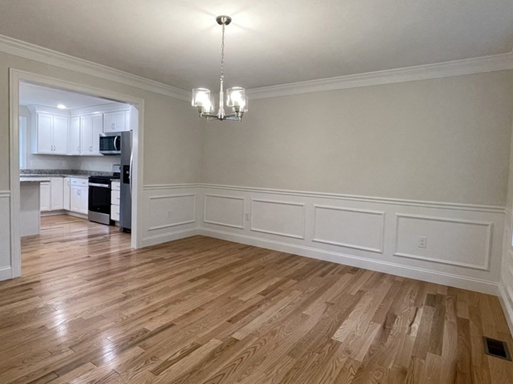 492 Northfield Road Lunenburg, MA 01462 - Photo 3 of 39 a view of empty room with wooden floor and kitchen