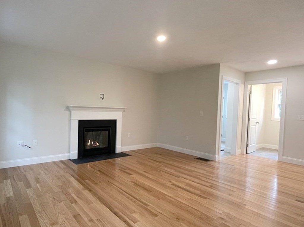 492 Northfield Road Lunenburg, MA 01462 - Photo 4 of 39 an empty room with wooden floor and a fireplace