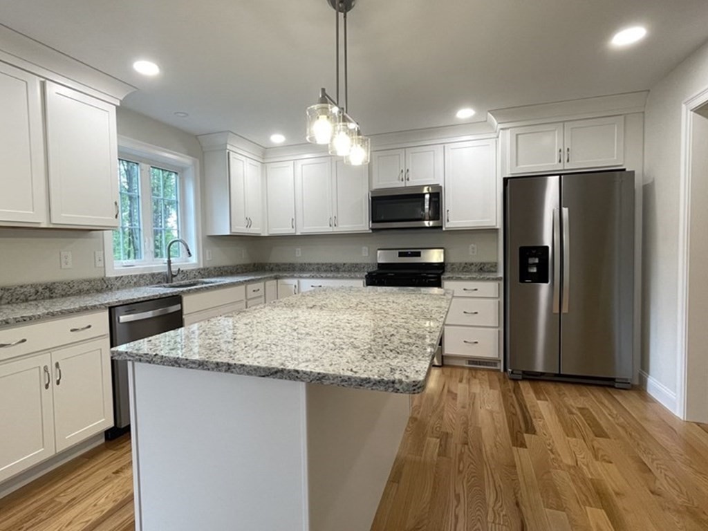 492 Northfield Road Lunenburg, MA 01462 - Photo 7 of 39 a kitchen with kitchen island granite countertop a sink a counter top space appliances and cabinets