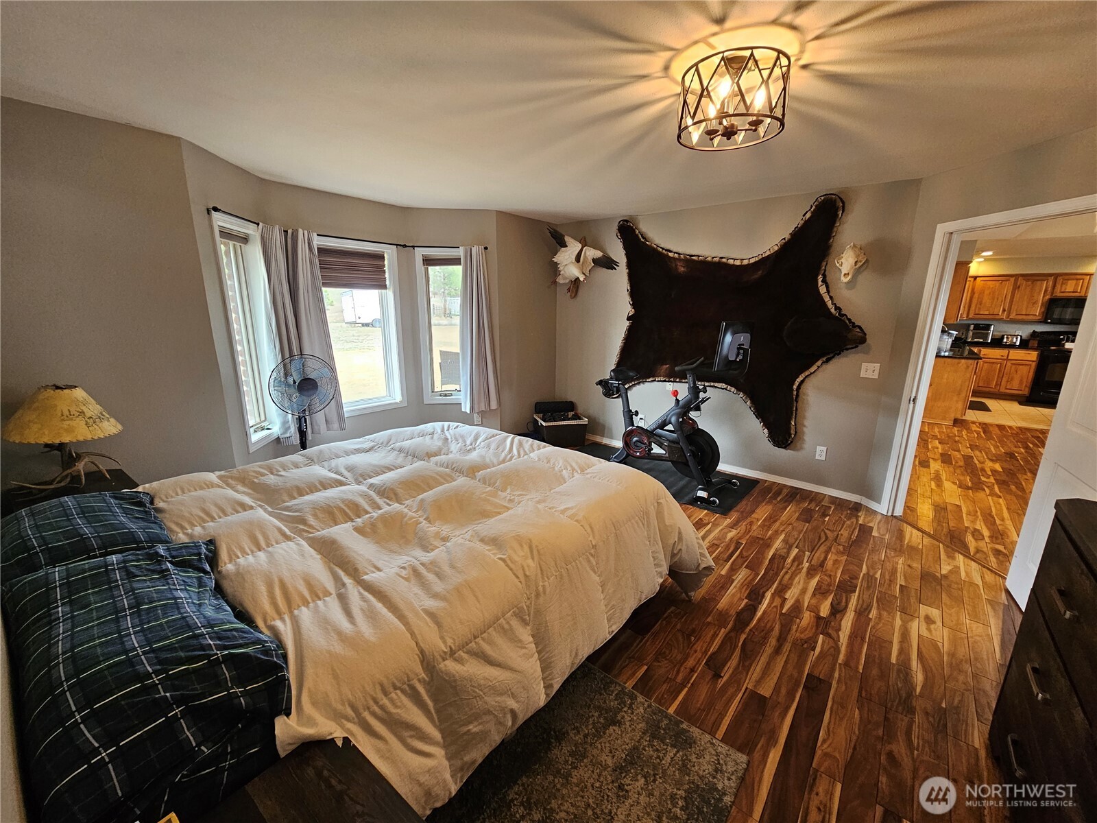 711 Havillah Road Tonasket, WA 98855 - Photo 17 of 40 a bedroom with a bed and dresser with wooden floor